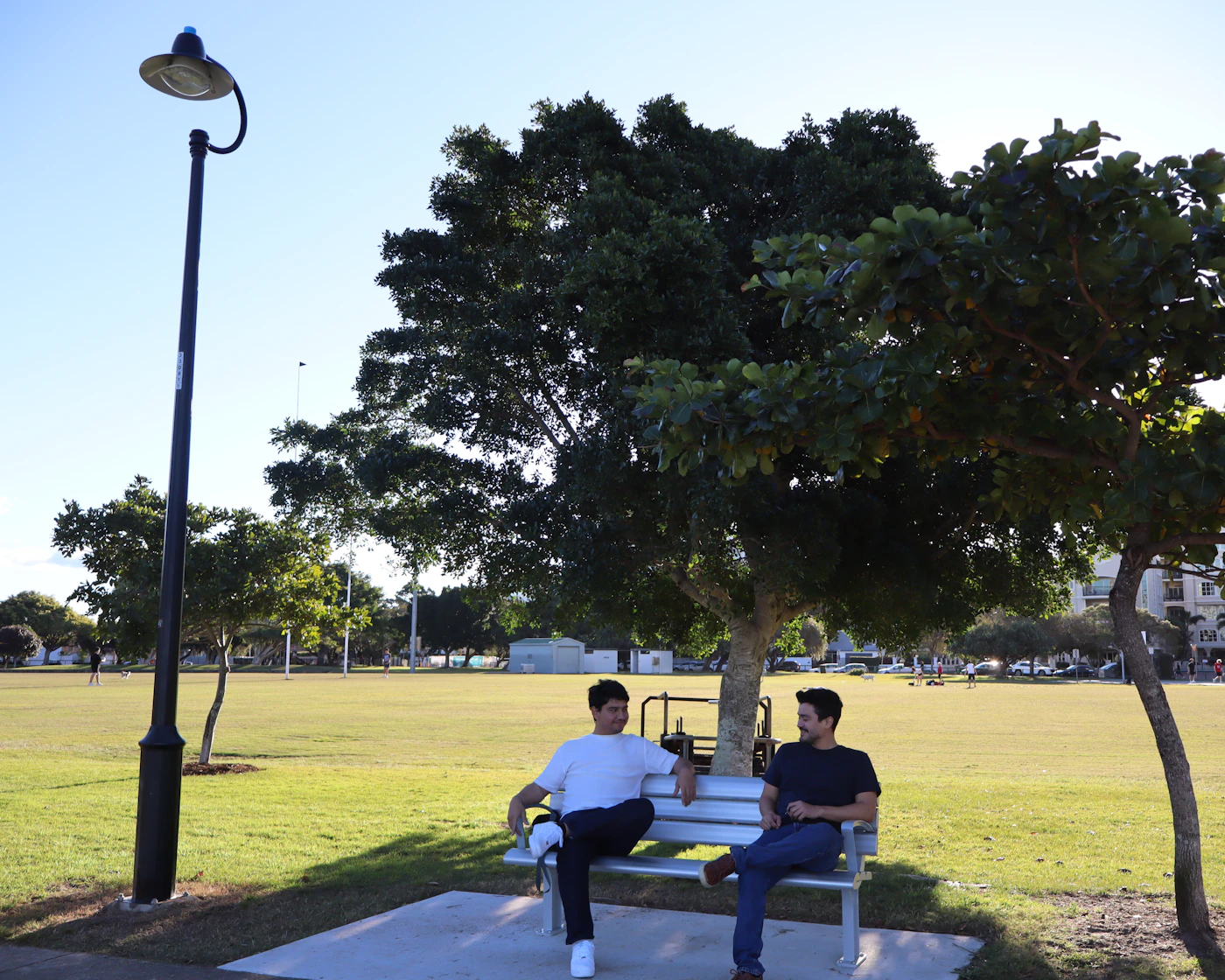 Two people talking together on a park bench
