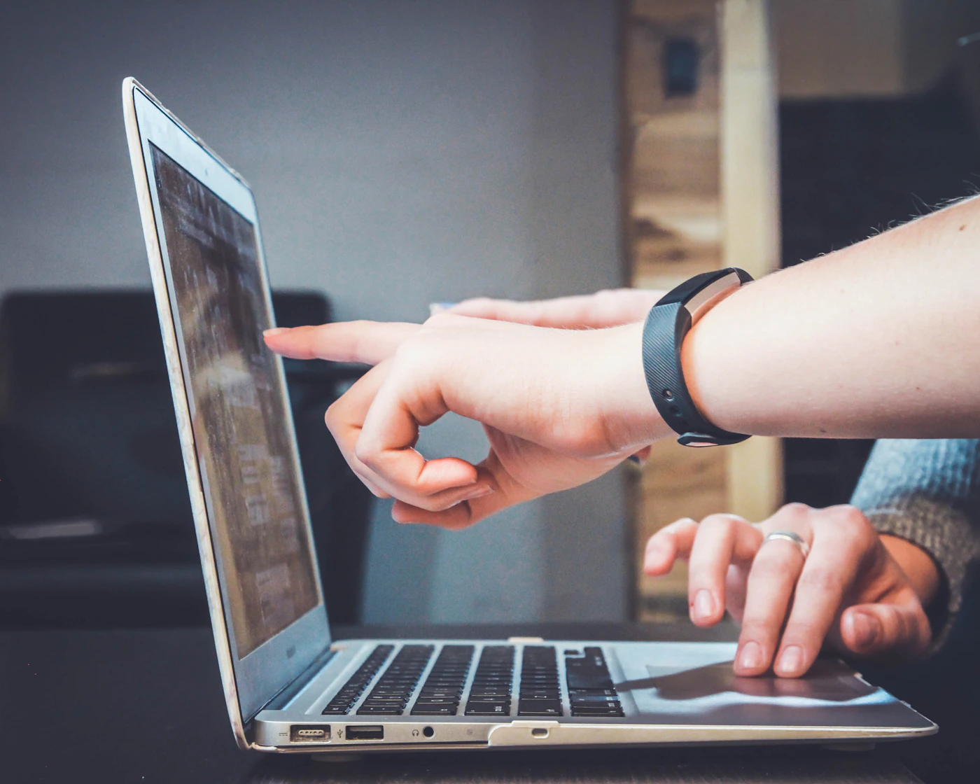Colleagues collaborating around a laptop