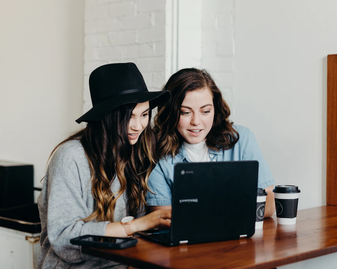 Two people discussing information together at a laptop
